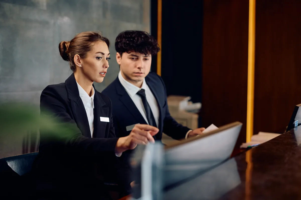Hotel front desk team reviewing guest arrivals
