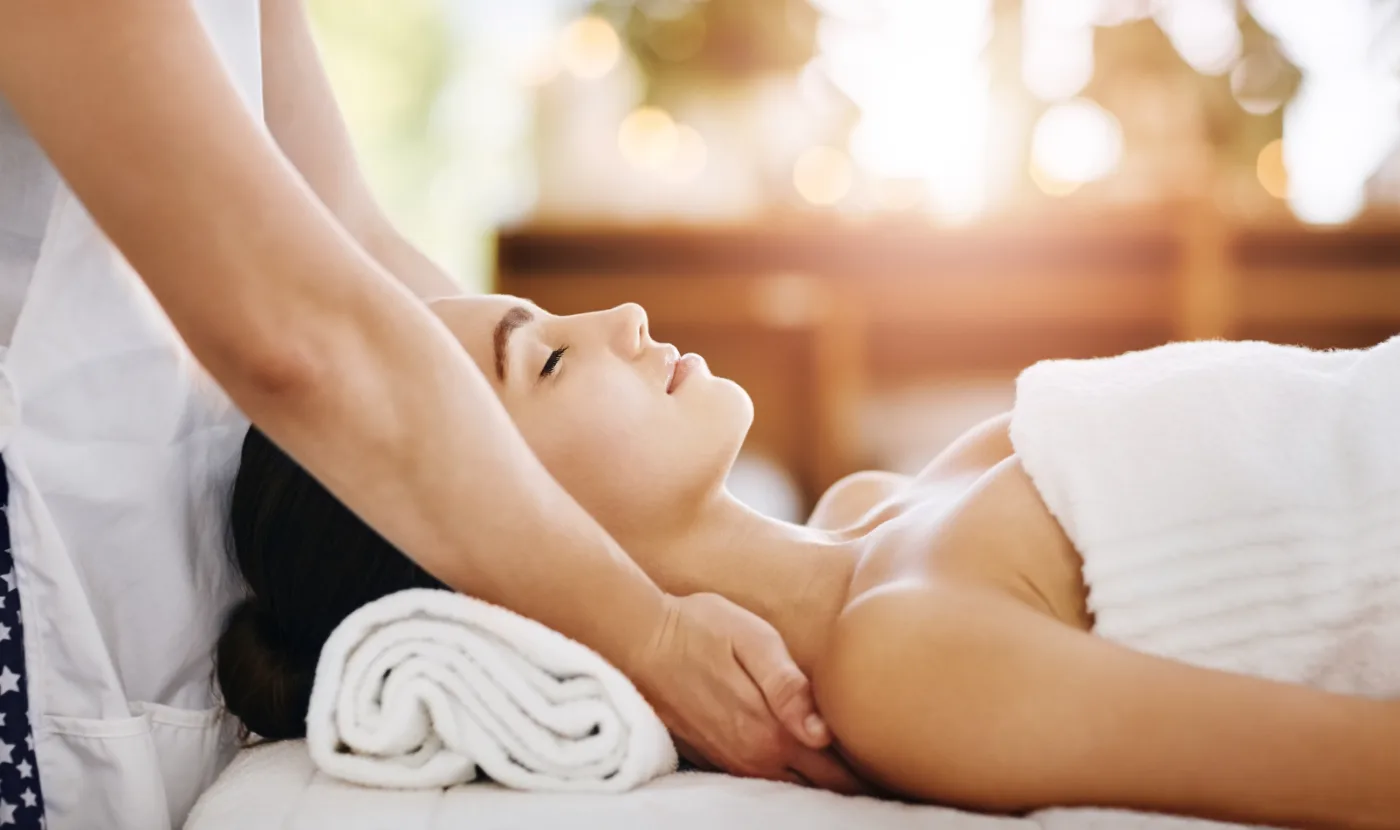 Massage therapist working on a client in a spa treatment room