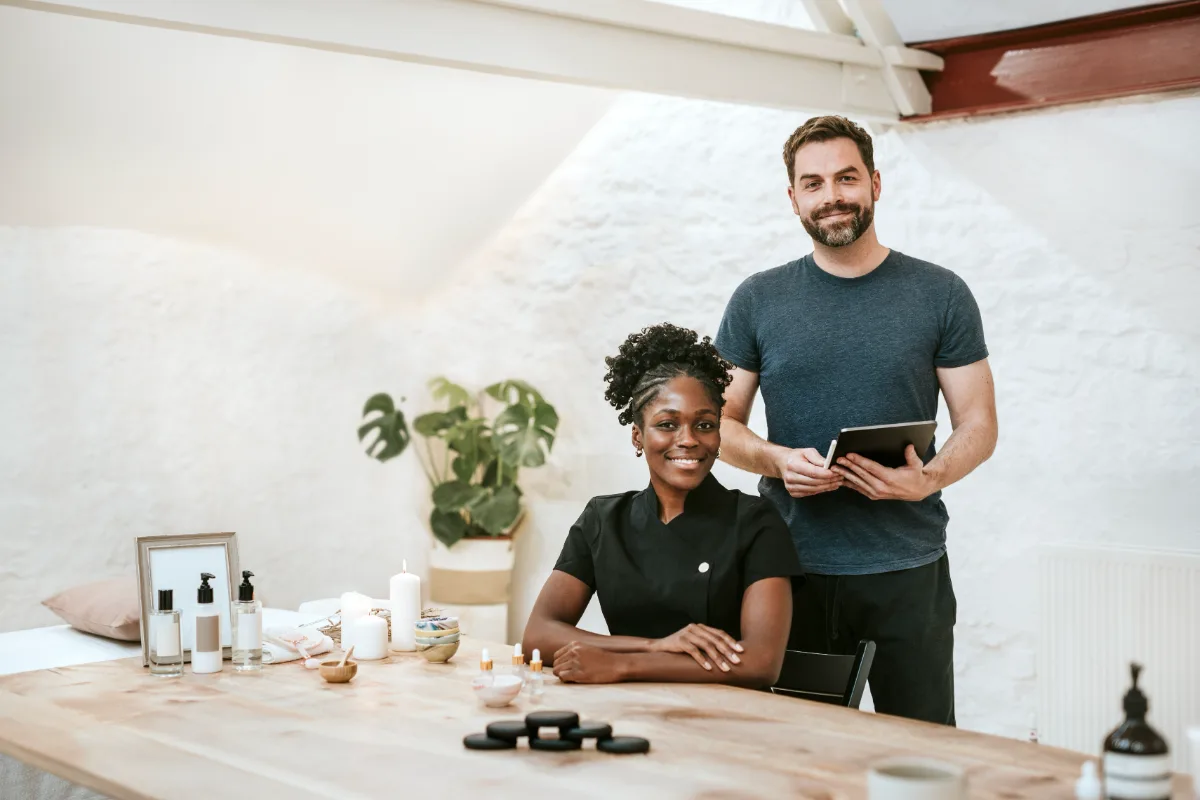 Spa manager and therapist standing at a treatment room reception table
